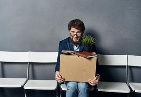 Man sitting on white chair waiting for lighting box job search depression photo