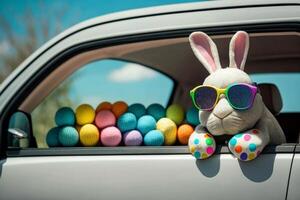 Cute Easter bunny in glasses looking out of a car filled with easter eggs, photo