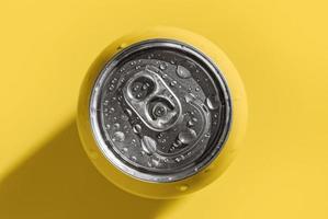 Yellow pop can with refreshing lemon tonic drink on yellow background, minimalism photo