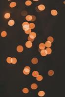 orange background festive bokeh light effect on dark background photo