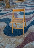 Explanada promenade in Alicante Spain landmark with wooden empty chair on mosaic photo