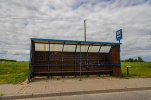 an old  shed at a bus stop on a country road somewhere in Poland photo