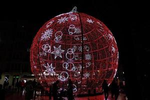 big glowing red bauble Christmas decoration in Alicante, Spain at night photo