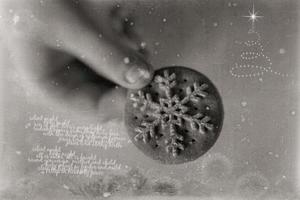 l tasty gingerbread with white snowflake decoration for Christmas kept in the hand of a chil photo