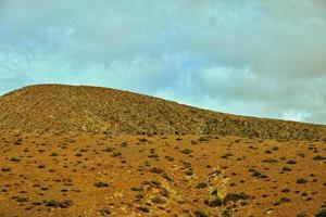 empty mysterious mountainous landscape from the center of the Canary Island Spanish Fuerteventura with a cloudy sky photo