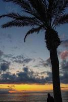 picturesque ocean landscape with the setting sun in a tropical country during summer holidays with palm photo