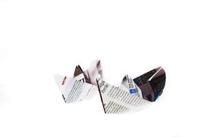 origami ship from newspaper on white background photo