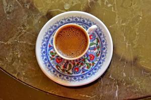 hot aromatic sweet black Turkish coffee in a small colorful cup photo