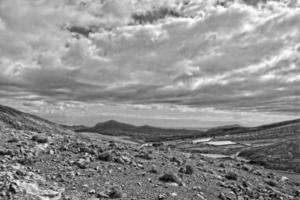 empty mysterious mountainous landscape from the center of the Canary Island Spanish Fuerteventura with a cloudy sky photo