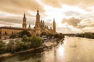 landscape from the Spanish city of Saragossa with the basilica and the Ebro river in the background of the sun setting in the sky photo