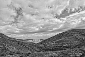 empty mysterious mountainous landscape from the center of the Canary Island Spanish Fuerteventura with a cloudy sky photo