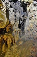 interesting original cave in the Turkish mountains with stalactites and stalagmites creating the background photo