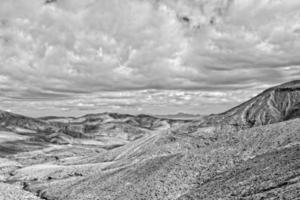 empty mysterious mountainous landscape from the center of the Canary Island Spanish Fuerteventura with a cloudy sky photo