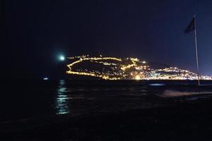 night view of the turkish city of alanya with lights on the hill photo