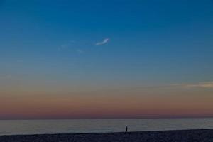 seaside landscape peace and quiet on a sunny warm day with a walking man minimalism photo