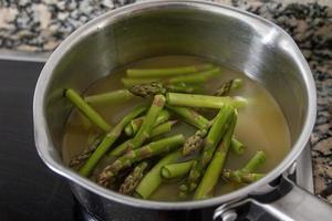 healthy green asparagus is cooked in a soup pot photo