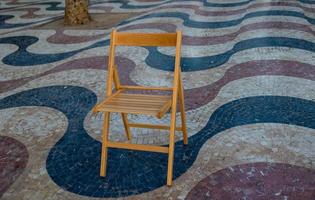 Explanada promenade in Alicante Spain landmark with wooden empty chair on mosaic photo