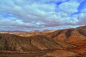 empty mysterious mountainous landscape from the center of the Canary Island Spanish Fuerteventura with a cloudy sky photo