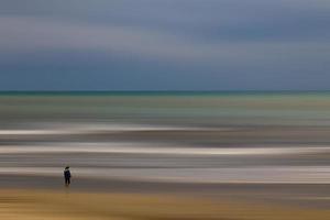 serene landscape of a woman on the shores of the blue sea photo