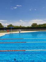 ver al aire libre piscina con nadando carriles en verano soleado fiesta día foto