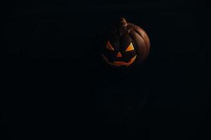 chocolate halloween pumpkin jack-o-lantern on dark background photo