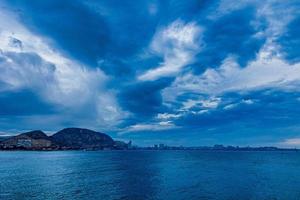 seaside landscape with clouds and sailboat on the horizon Alicante Spain photo