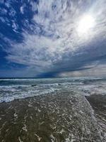 serene seaside landscape with sky with clouds and waves photo