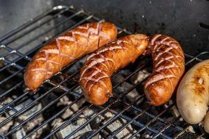 hot sausages lying on a hot grill close-up outside photo