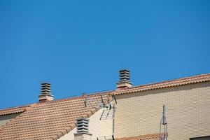 antecedentes con Español embaldosado techos de casas en contra un despejado azul cielo foto