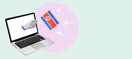 Art collage hand with the North Korea flag from a laptop on a light background. photo