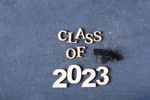 Class of 2023 concept. Wooden number 2023 with tinsel on dark background flat lay photo
