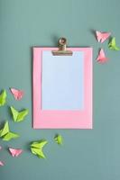 Massage board mockup with paper butterfies green and pink color flat lay on a colored background photo