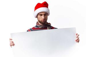 emotional man in a christmas hat with white mockup poster christmas light background photo