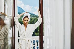 Portrait woman in a white robe on the balcony bit on green nature Mountain View photo