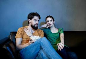 noche televisión acecho y un casado Pareja con palomitas de maiz en un plato foto