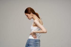 woman in white t-shirt chiropractic rheumatism health problems light background photo