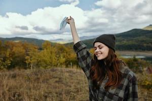 Happy traveler with medical mask in the river in the autumn forest in the mountains photo