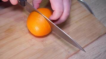 Frau Schneiden ein Orange mit ein Messer video