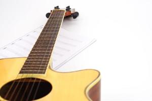 Acoustic guitar with music notes against white background. Entertainment, love and music concept. photo