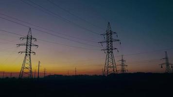 View from the height of power line silhouettes against sunset sky video