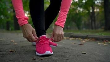 vicino su di donna in esecuzione attraverso un autunno parco a tramonto video