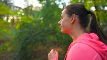 Close up of woman running through an autumn park at sunset video