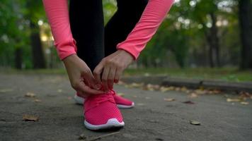 dichtbij omhoog van vrouw rennen door een herfst park Bij zonsondergang video