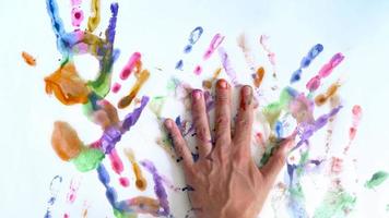 criativo conceito - homem e mulher faço impressões do seus pintado mãos em uma branco fundo video