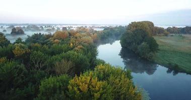 Aerial view of the meadow and river covered with fog at dawn. Ukraine video