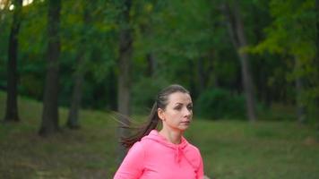 cerca arriba de mujer corriendo mediante un otoño parque a puesta de sol video