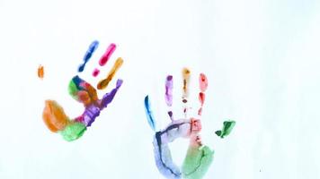 Creative concept - man and woman make prints of their painted hands on a white background video