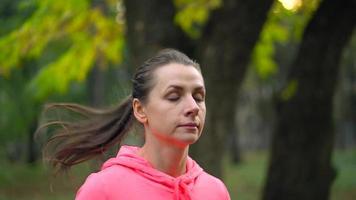 proche en haut de femme fonctionnement par un l'automne parc à le coucher du soleil video