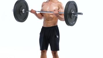 Man flexes his hands with dumbbells, training his shoulders on a white background in the studio video