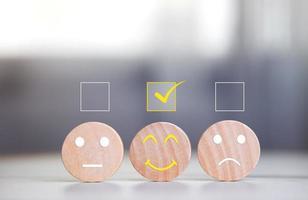 Various emotional expressions on a round wooden board with a check mark on table. Concept of satisfaction survey, mental health rating scale by best rating photo